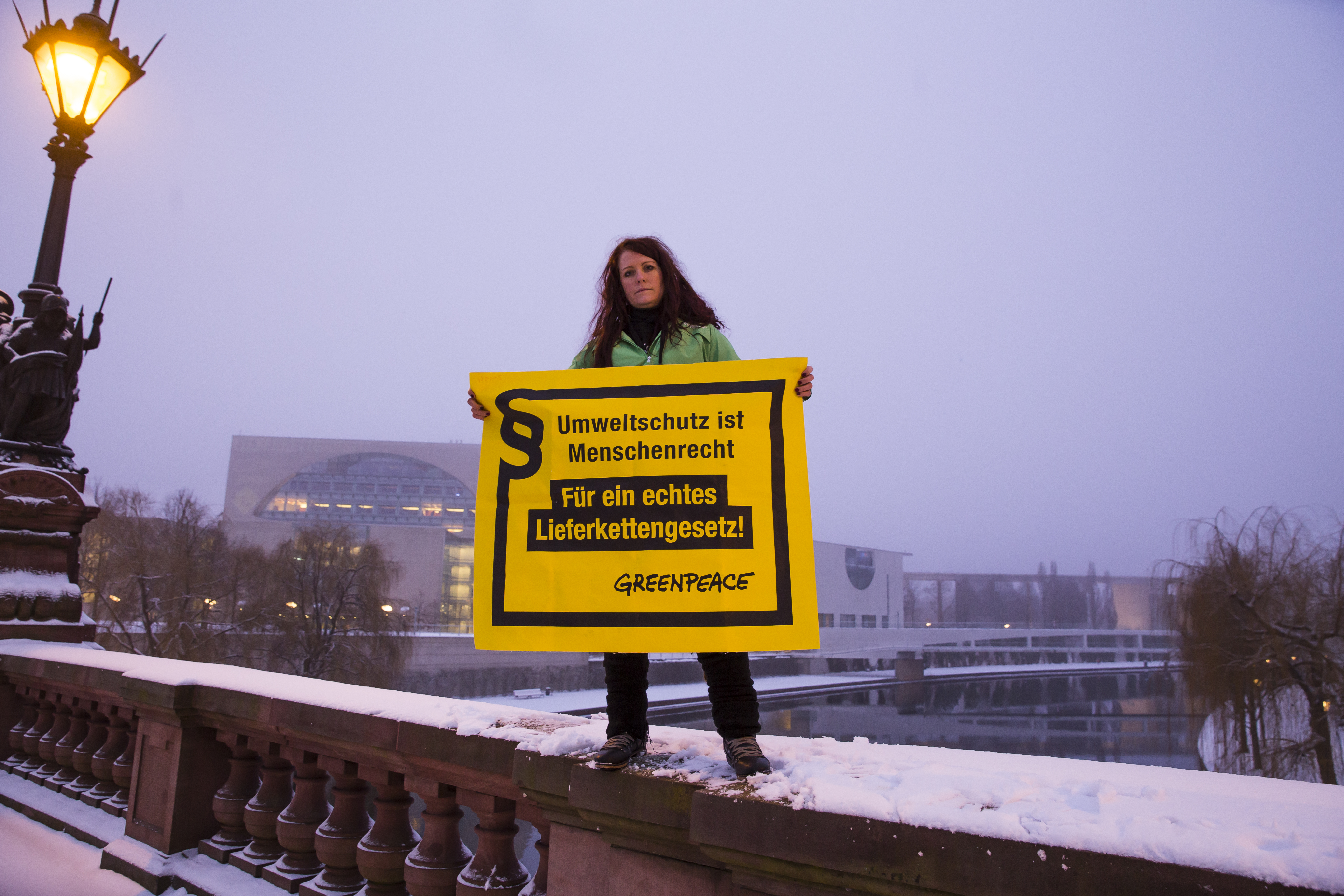 Eine Greenpeace-Aktivistin hält ein Banner hoch mit der Aufschrift 