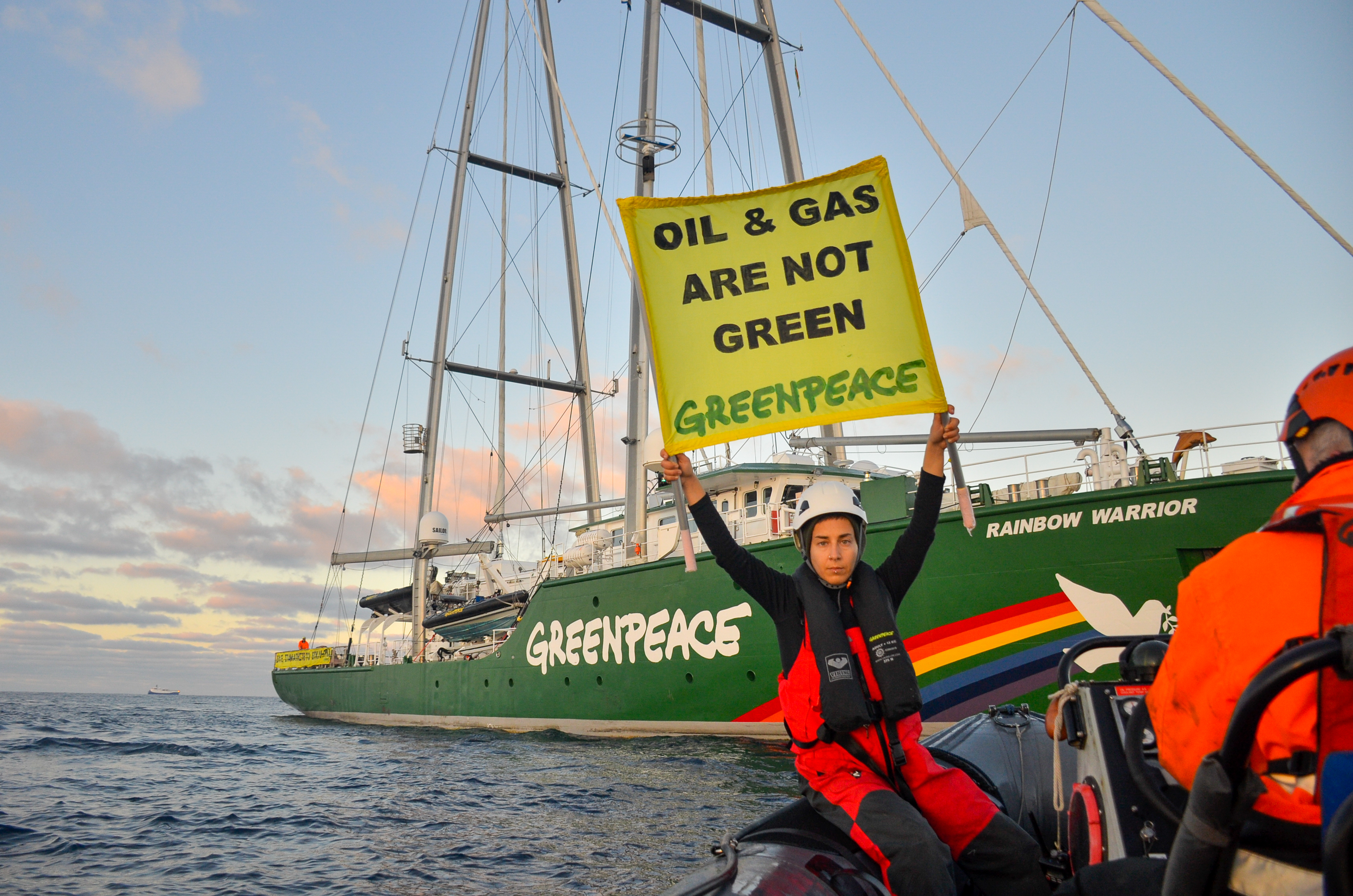 Aktivist:innen vor dem Greenpeace Segelboot 