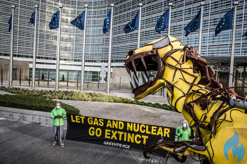 Zwei Greenpeace Aktivisten stehen vor der Europäischen Kommission mit einem Schild auf dem steht: 