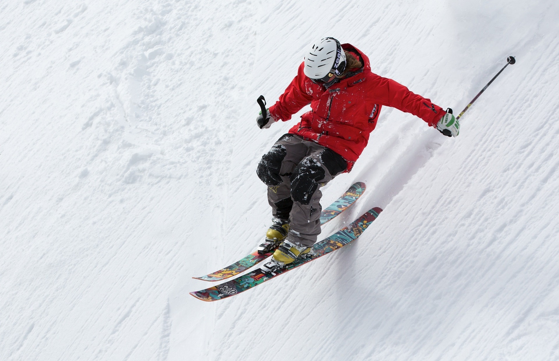 Ein Skifahrer fährt mit hoher Geschwindigkeit einen Hand hinunter.