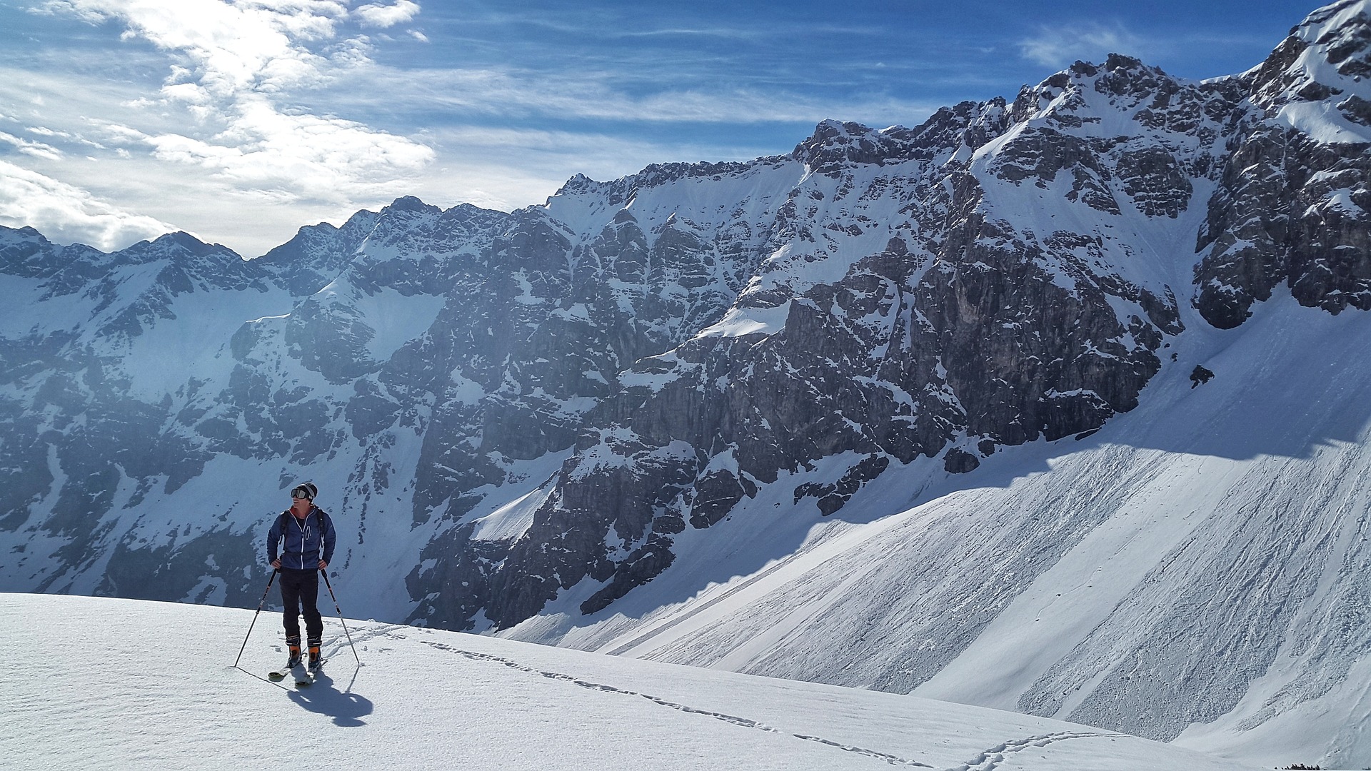 Bergpanorama, im Vordergrund ein Skifahrer